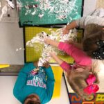 Girls playing with shaving cream and cranberries