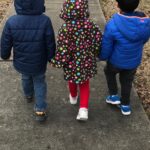 children holding hands walking together