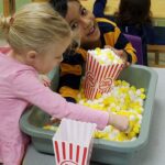 children exploring a popcorn sensory tub